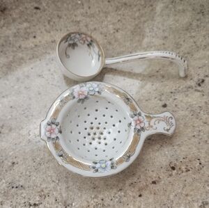 Antique tea strainer set with a spoon.